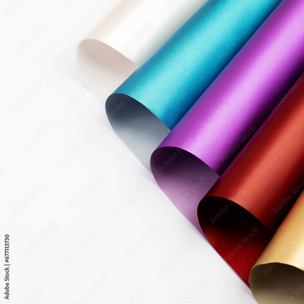 Different colorful wrapping paper rolls on white background, close up. Rolls of deep colors wrapping paper Different colorful wrapping paper rolls on white background, close up. Rolls of deep colors wrapping paper