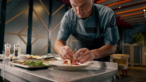 Close-up chef preparing bruschetta laying out beef avocado and tomatoes in professional kitchen in Italian restaurant