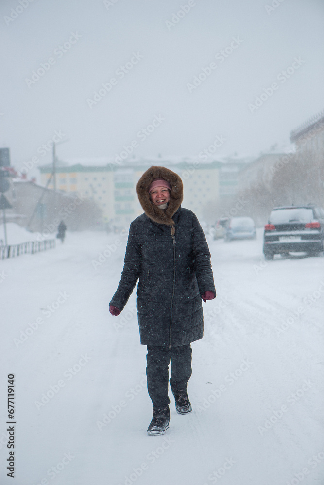 Winter is coming by severe blizzard. Poor visibility in heavy snow storm on path. Woman slowly and hard walking in dangerous weather day. Cataclysm of nature. City people life in blizzard concept