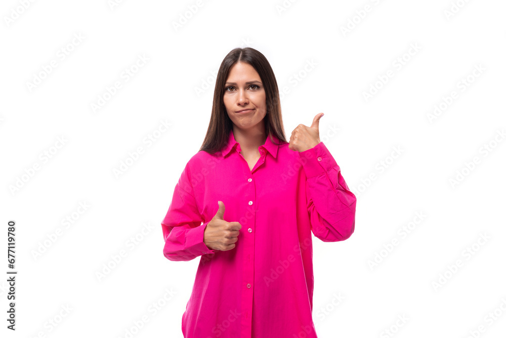 a cute young brunette european woman in a crimson shirt uses gestures to carry on a conversation
