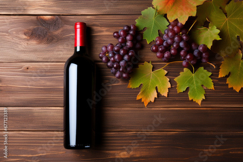 Bottle of red wine, grape and autumn leaves on wood background