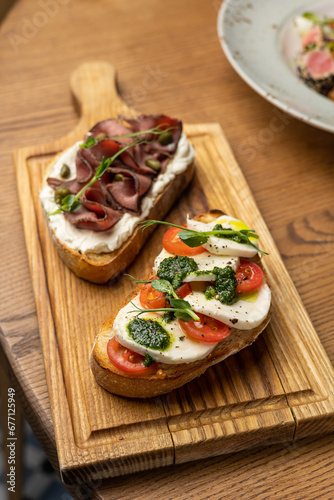 Tasty bruschetta with jamon and cheese on a wooden table
