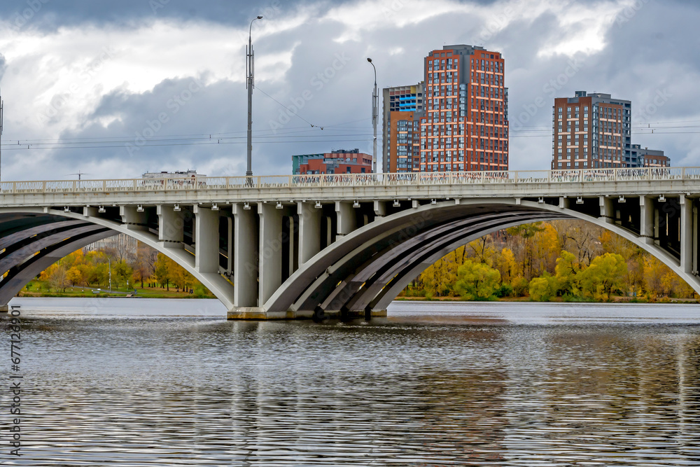 Obraz premium Fragment of a river arch bridge on an autumn day