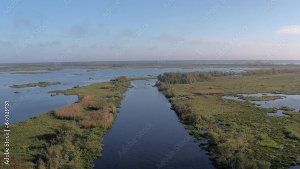 Aerial Backward Shot Of Motorboat Moving In Tranquil River Against Cloudy Sky - Bayou, Louisiana Aerial Backward Shot Of Motorboat Moving In Tranquil River Against Cloudy Sky - Bayou, Louisiana