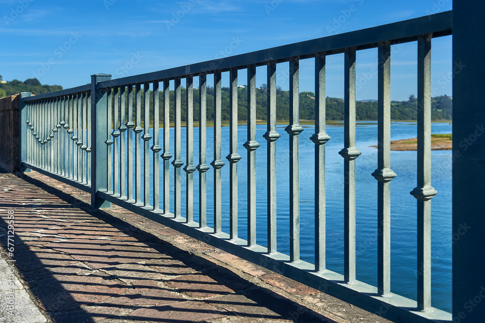 metal railing of a bridge with decorative steel bars in the shape of a waving knot metal railing of a bridge with decorative steel bars in the shape of a waving knot