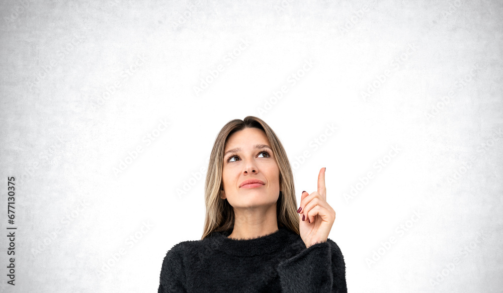 Thoughtful woman with raised index finger Thoughtful woman with raised index finger
