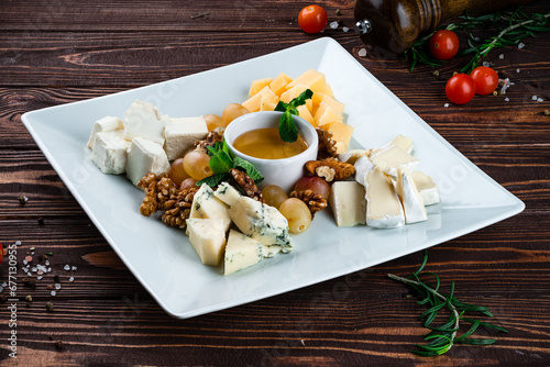 Set for wine dorblu cheese, parmesan, brie white cheese, walnuts, grapes, honey and mint, fresh snacks. photo