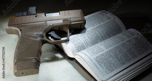 Bible open to the book of Luke with pistol on top photo