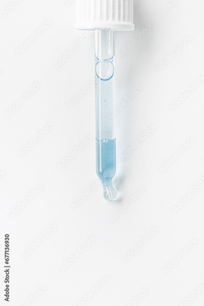 Cosmetic pipette with blue and blue gel, serum, serum on a light background. Cosmetic pipette with blue and blue gel, serum, serum on a light background.