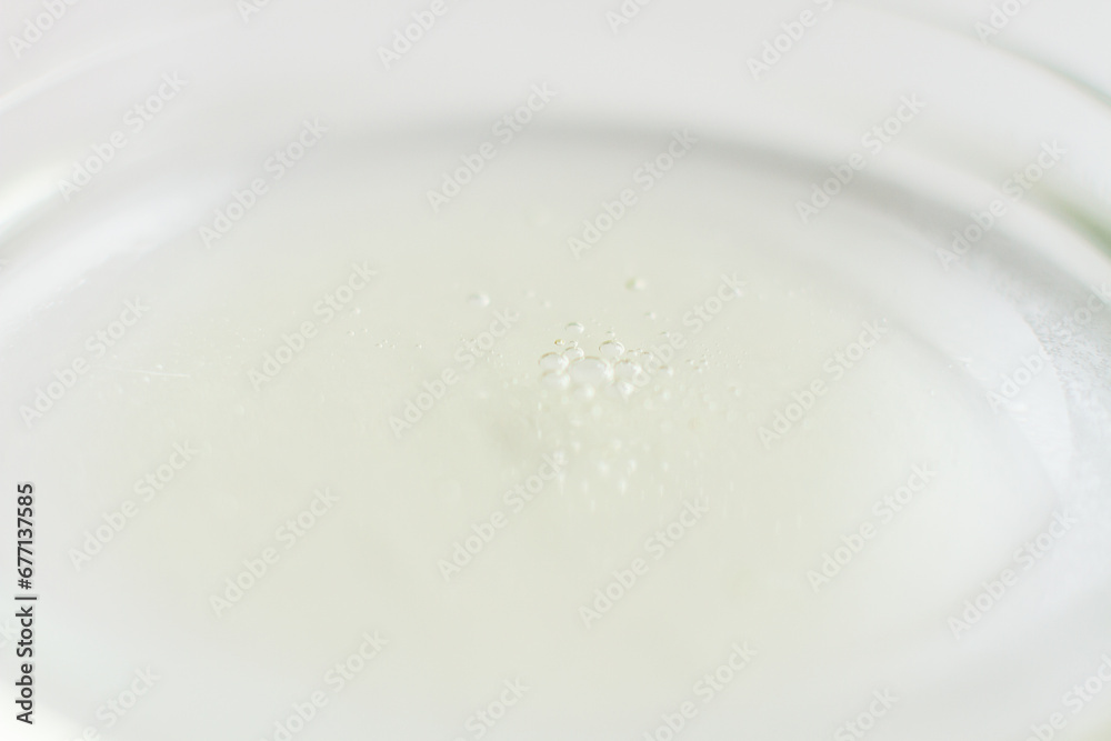 Petri dish with liquid and small bubbles on a light background Petri dish with liquid and small bubbles on a light background