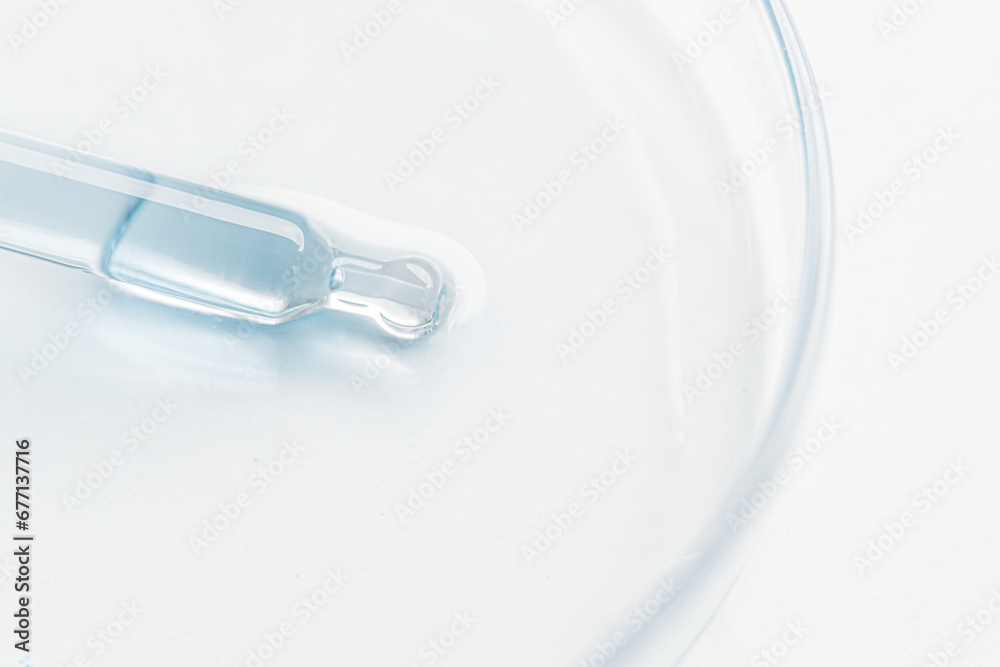 Petri dish. Cosmetic pipette with blue and blue gel, serum, serum on a light background. Petri dish. Cosmetic pipette with blue and blue gel, serum, serum on a light background.