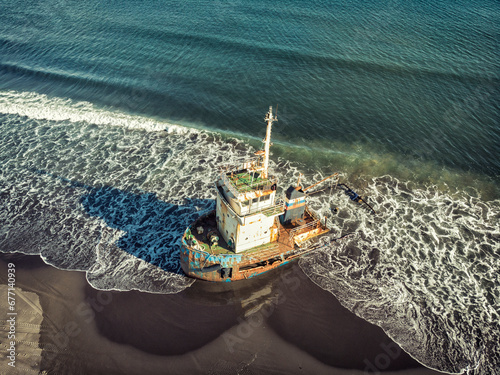 A sunken ship washed ashore Iturup, Kuril Islands. Russia photo