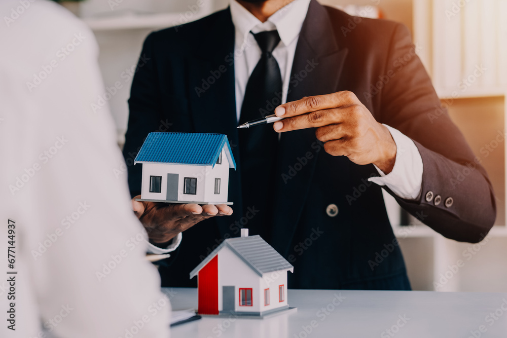 Accountant, businessman, real estate agent, Asian business woman handing keys to customers along with house after customers to sign Accountant, businessman, real estate agent, Asian business woman handing keys to customers along with house after customers to sign