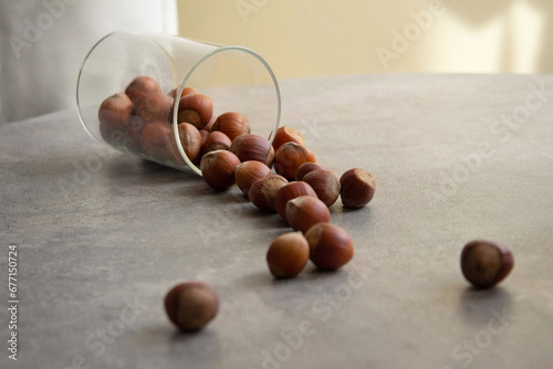 Hazelnuts spilled from a glass container