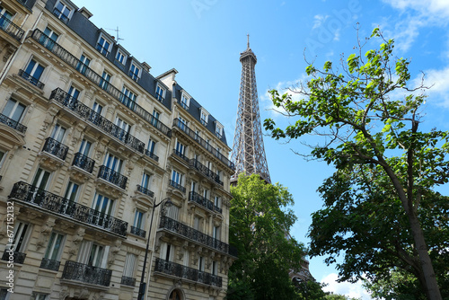 Eiffel tower by day. View on historic monument with old building in the foreground.