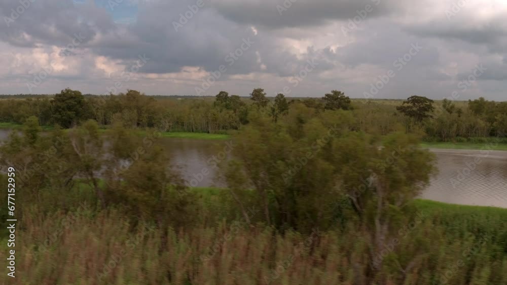 Aerial Panning Scenic Shot Of Airboat Moving In Rippled River On Sunny Day - Bayou, Louisiana