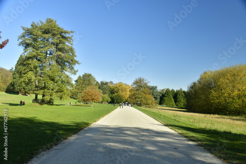 L' allée centrale traversant une pelouse entre certains arbres majestueux au domaine du château de la Hulpe en Brabant Wallon 