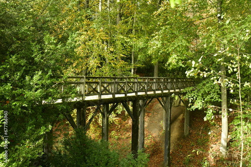Le pont en rocaille rustique traversant un petit ravin sous la végétation luxuriante de la forêt au domaine du château de la Hulpe  photo