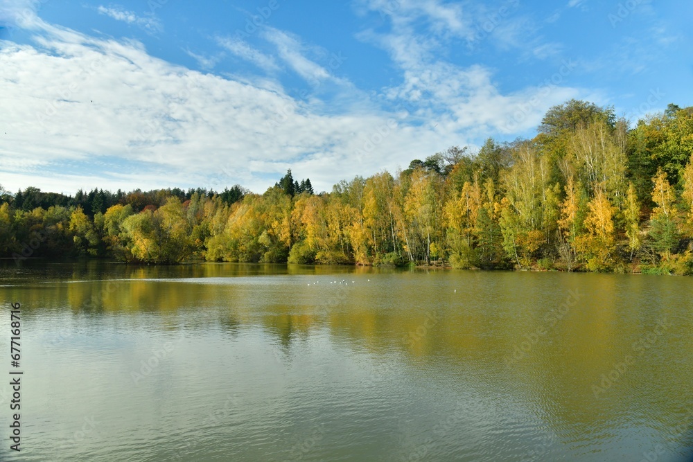 La beauté bucolique des feuillage vert-dorés des arbres se reflétant dans les eaux de l'étang au domaine du château de la Hulpe 