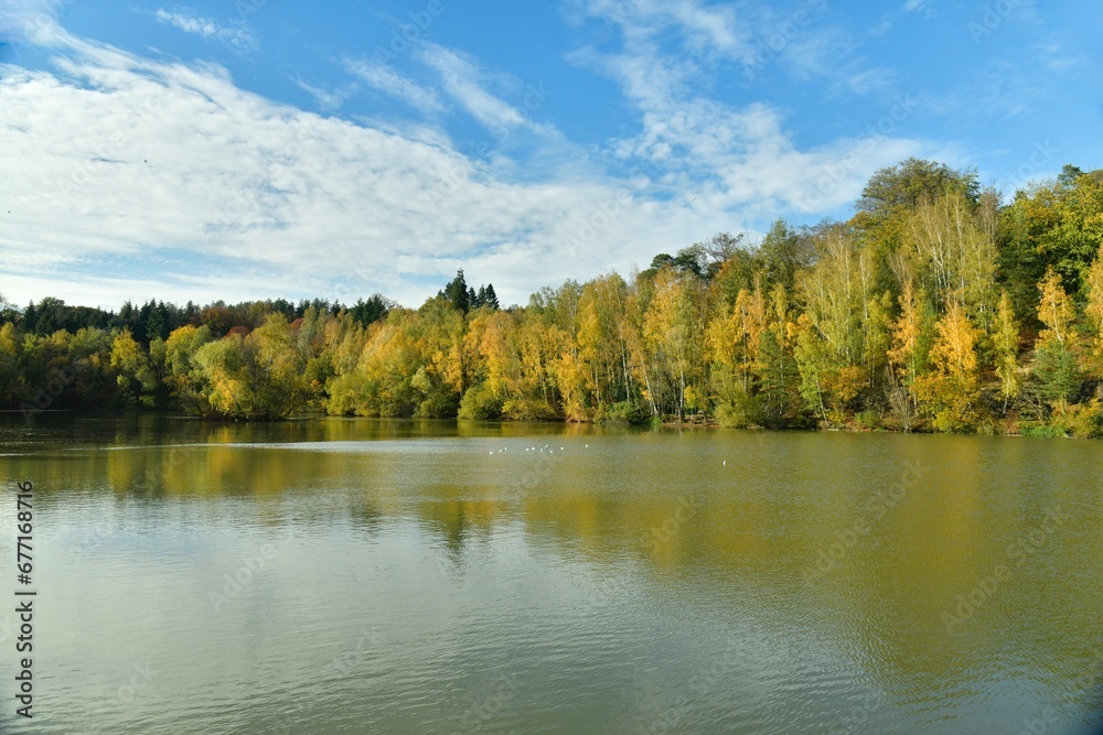 La beauté bucolique des feuillage vert-dorés des arbres se reflétant dans les eaux de l'étang au domaine du château de la Hulpe La beauté bucolique des feuillage vert-dorés des arbres se reflétant dans les eaux de l'étang au domaine du château de la Hulpe