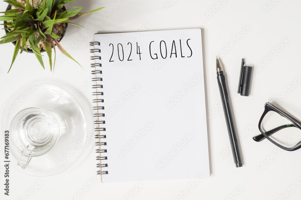Notebook with 2024 goals text on it to apply new year resolutions and plan. - obrazy, fototapety, plakaty 