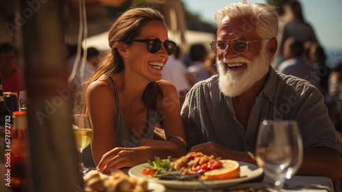 Photo of A cheerful elderly couple participate in a Mediterranean feast with an abundance of seafood  cheese  wine a small village  against the backdrop of a picturesque sea. Active age concept