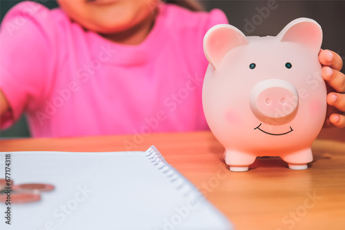 A child learns to save with his pink piggy bank, small saving