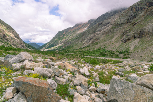 Panorama of a gorge in a mountainous area. Granite stones in the mountains.  Landscape in summer with views of mountains, clouds and flowers. Hiking in the mountains. A trip to the mountains. © Eduard Belkin