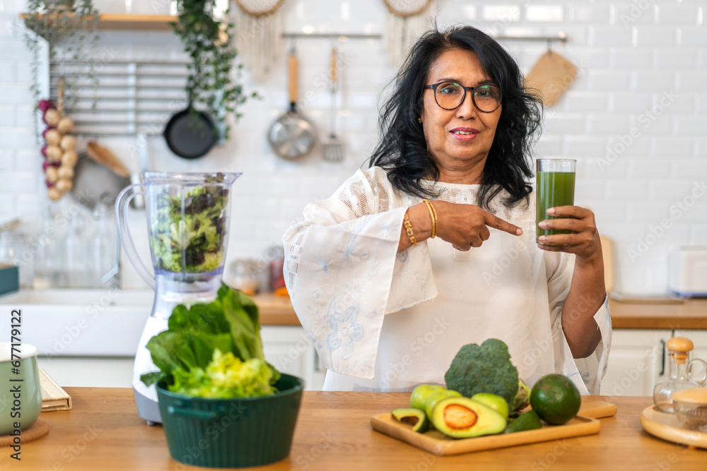 Portrait senior healthy asian woman making green vegetables detox cleanse and green fruit smoothie with blender.elderly woman drinking glass of green fruit smoothie in kitchen.healthcare, insurance