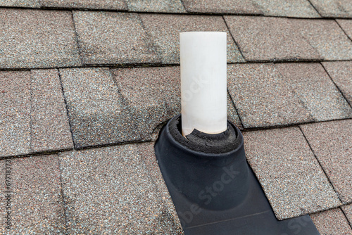 Old vent pipe flashing boot on roof of house. Roofing repair, home maintenance, and home inspection concept