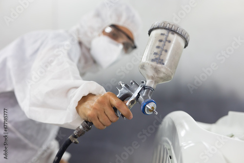 close up paint spray gun. paint garage. car in paint room at garage. Auto mechanic car hispanic man worker working painting in car paint chamber. Body paint garage