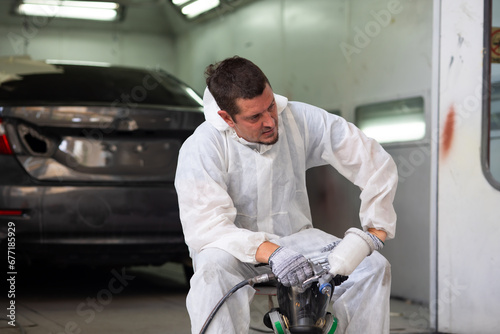 Tired hot wiping sweat worker. paint garage. paint room at garage. Auto mechanic car hispanic man worker working painting in car paint chamber. Body paint garage