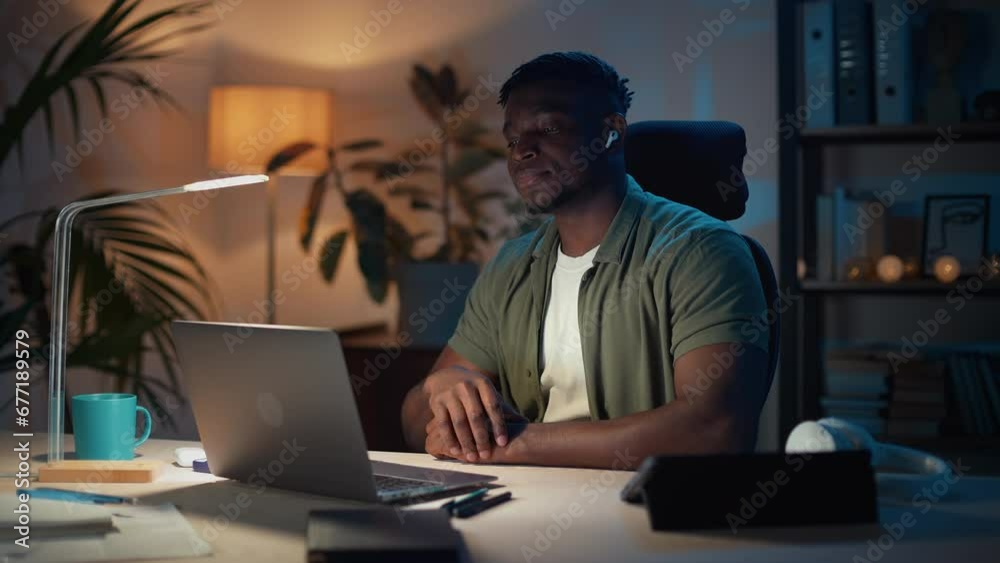 Man taking off earphones while finishing online meeting Man taking off earphones while finishing online meeting
