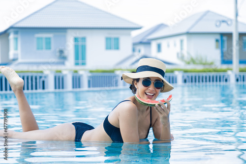 Luxury lifestyle businesswoman wearing bikinis swimwear and hats with eyeglasses eating tropical fruit watermelon while sunbathing, healthy Hispanic females happy relaxing summer holiday vacation © Rakchanok