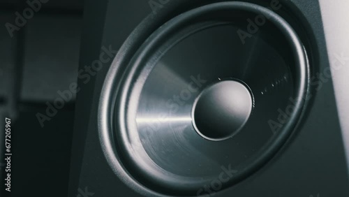 Studio bass speaker vibrates from loud music in a recording studio, close-up. Modern loudspeaker membrane pumping from bass sound in slow motion. Working bass cone on low frequency. Hi-fi sound system photo