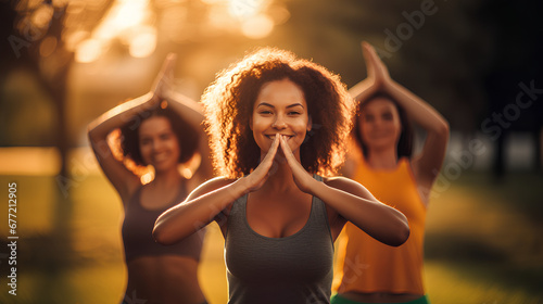 A group of cheerful young women practice relaxed and mindful yoga exercises with a mat in a beautiful city park at sunset, AI generated photo