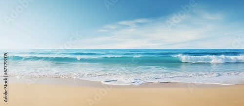 The blue ocean waves crash against the sandy beach creating a stunning landscape with a mesmerizing view of the horizon and coastline making it the perfect spot for fishing or enjoying a pea