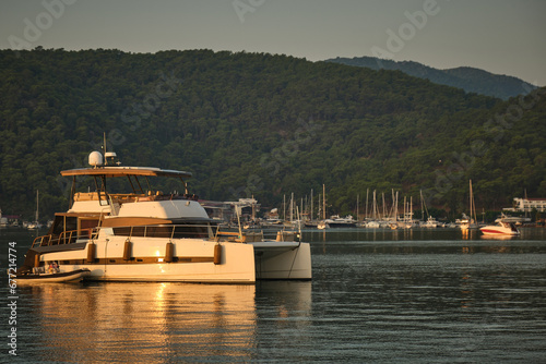 Catamaran at sunset in the bay against the backdrop of the mountains.