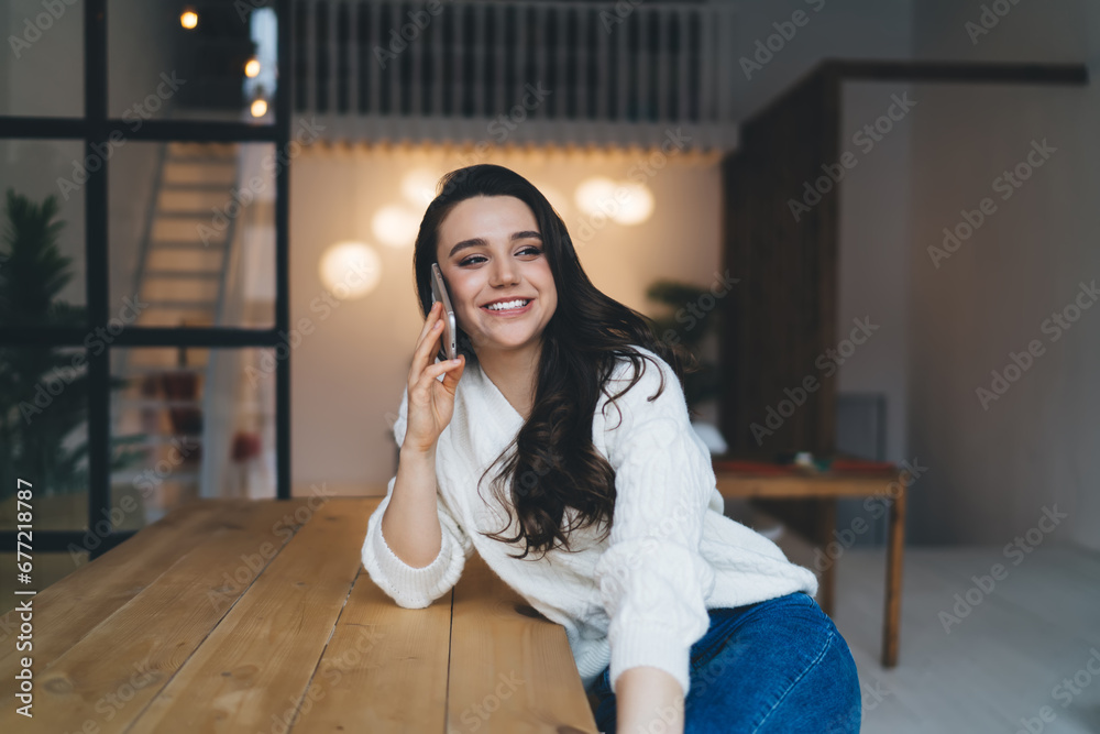 Happy lady having phone conversation at table Happy lady having phone conversation at table
