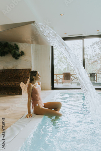Young woman relaxing by the indoor swimming pool