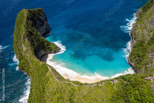 Drone view of Cap de T-Rex, Kelingking Beach and steep cliffside stairs on sunny day. Nusa Penida Island, Indonesia.