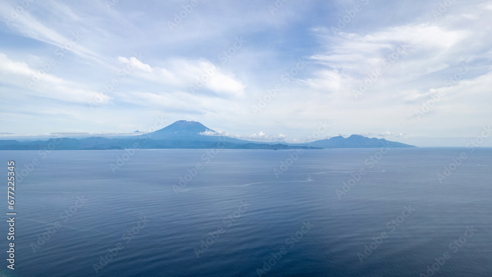 Aerial view of Bali and Mount Agung from above Nusa Penida Island on sunny day. Indonesia. Aerial view of Bali and Mount Agung from above Nusa Penida Island on sunny day. Indonesia.