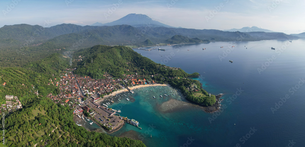 Panoramic drone view of Padangbai and Mount Agung on sunny day. Manggis, Bali, Indonesia.