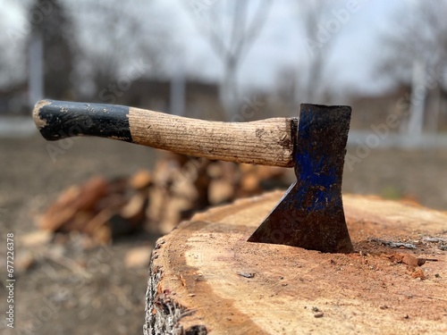Closeup shot of an axe stucking in a stump in the forest photo