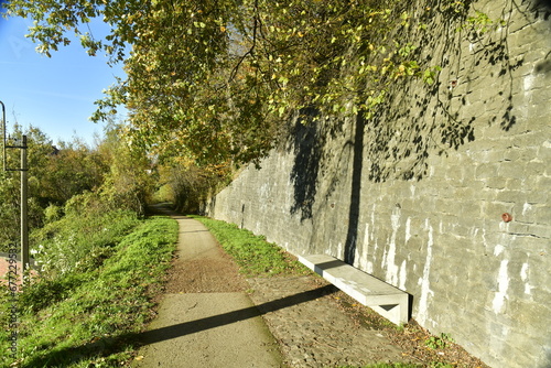 Coin de repos le long d'un vieux mur en pierres sous un feuillage d'automne à la forêt de Morlanwelz 