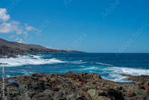 Beautiful landscape with deep blue water. Powerful waves crash against black volcanic rocks on the coast of ´Aguas Verdes, Fuerteventura island.