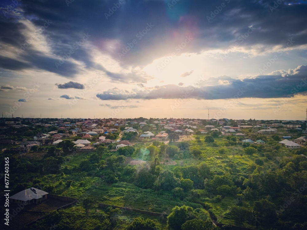 Aerial shot of a sunset in village and tree-covered land