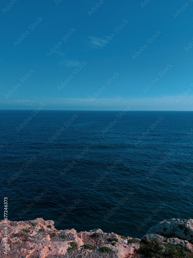 Vertical shot of the blue seascape under the clear sky in Mallorca, Spain Vertical shot of the blue seascape under the clear sky in Mallorca, Spain
