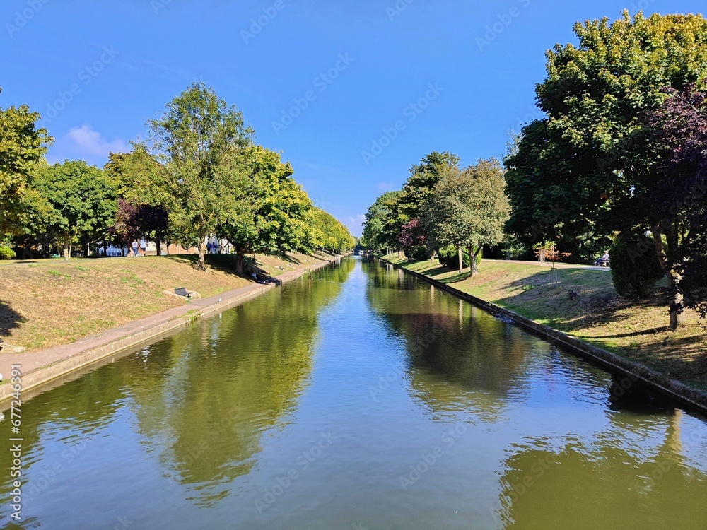 Landscape of a canal in the park with green trees