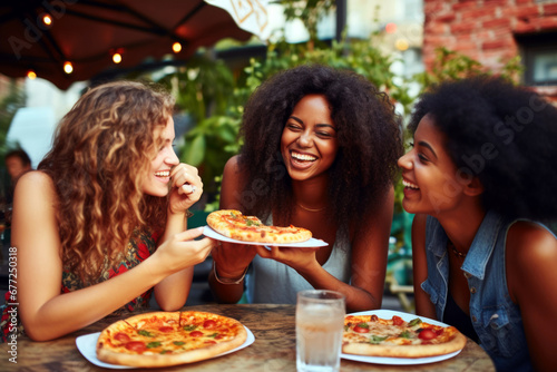 Three happy female friends eating pizza in restaurant © Danny